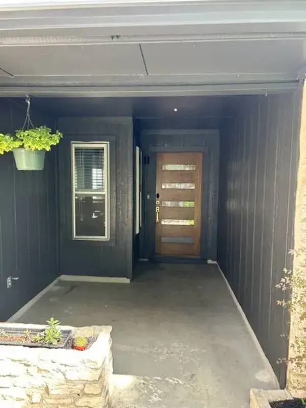 Home entryway after exterior painting — dark charcoal trim against limestone by V&S Services