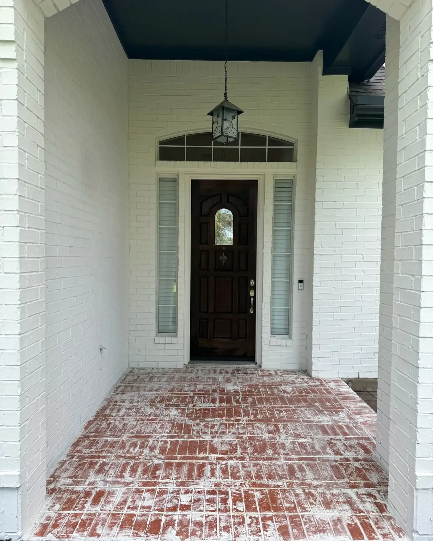 After: Arched brick front entry painted bright white in Pflugerville, TX
