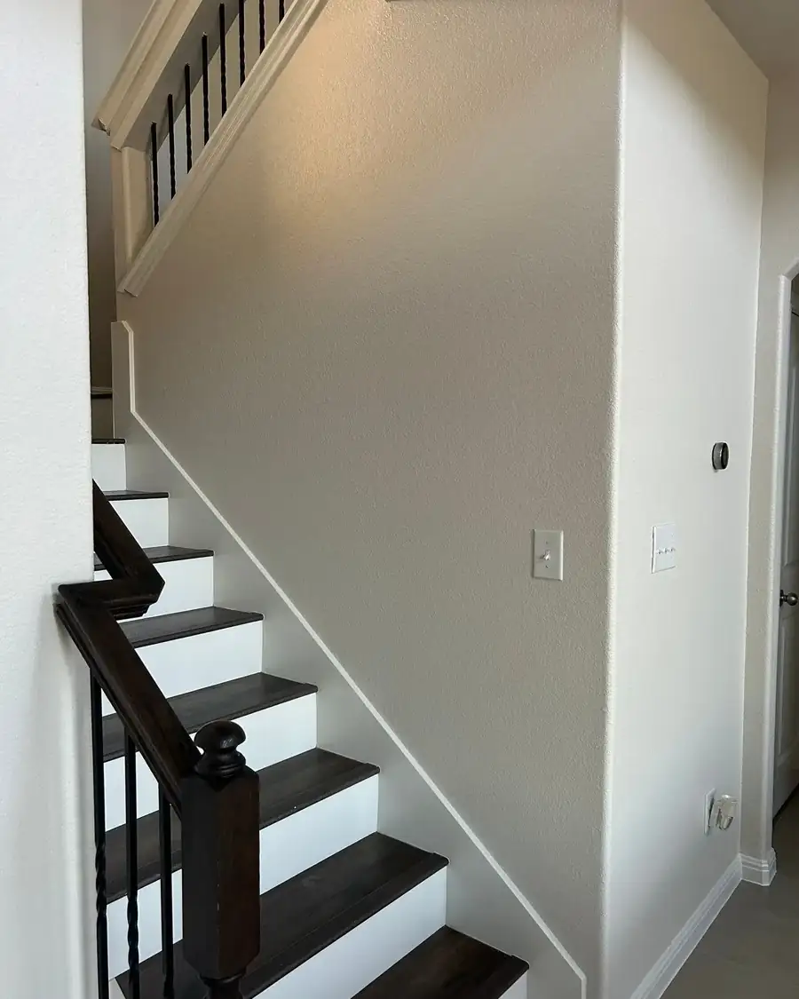 After: Entry and stairwell walls, scuffed to fresh paint with crisp trim in Austin, TX