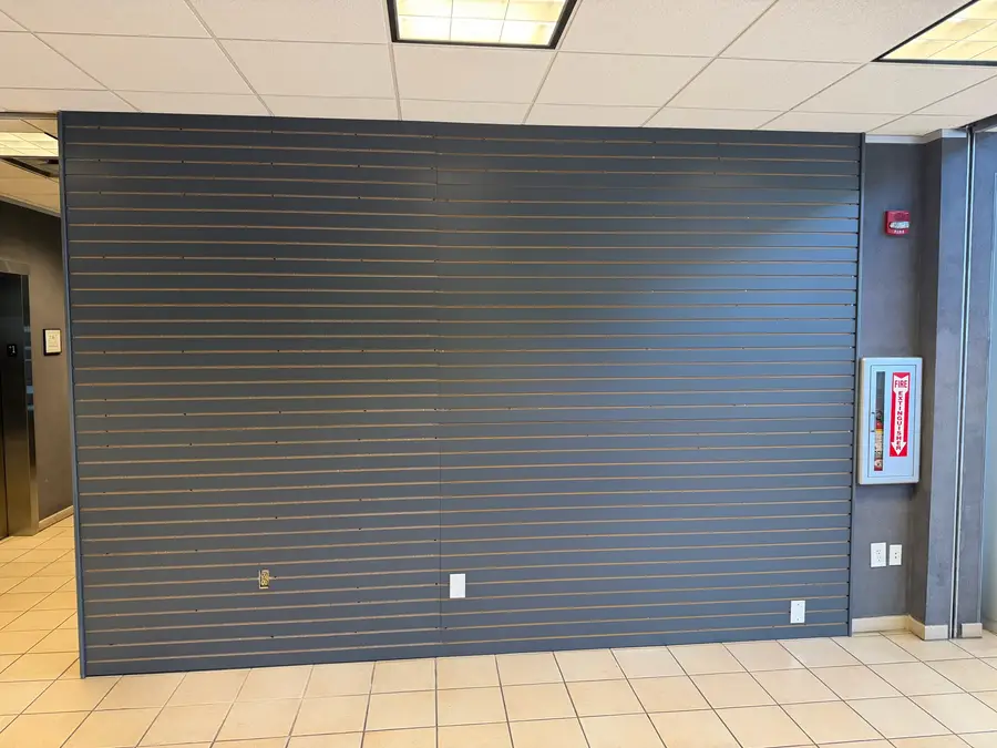 Same commercial slatwall after, repainted deep navy by V&S Painting, Austin