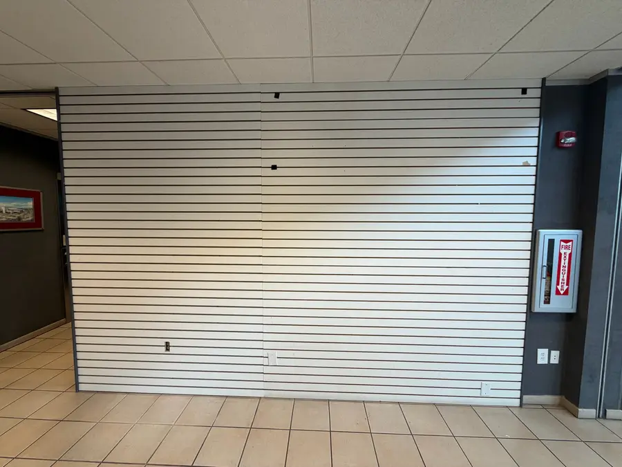 Commercial lobby slatwall before painting, scuffed white finish, Austin TX
