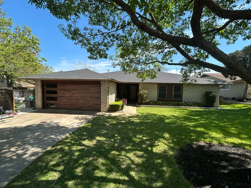 Austin home exterior painted black with a modern wood front door by V&S Services