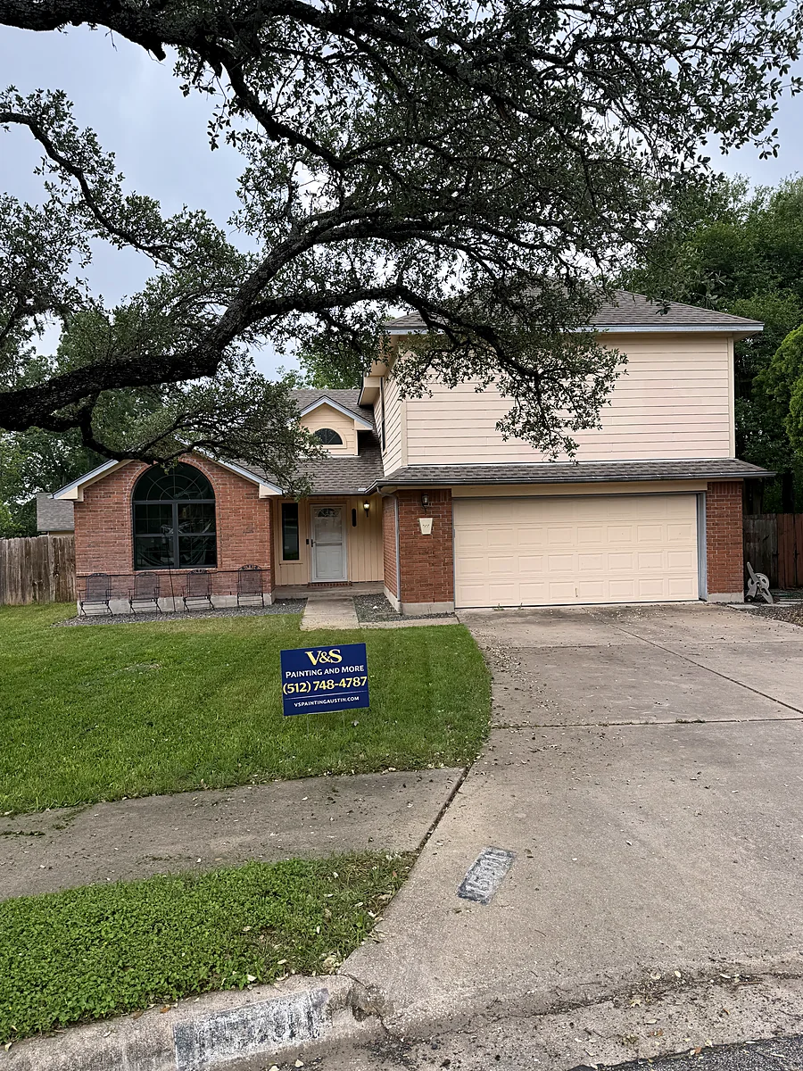 Red brick two story Austin home before painting, V&S sign in the yard