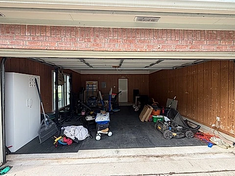 Garage before, dated wood paneling and clutter, Austin