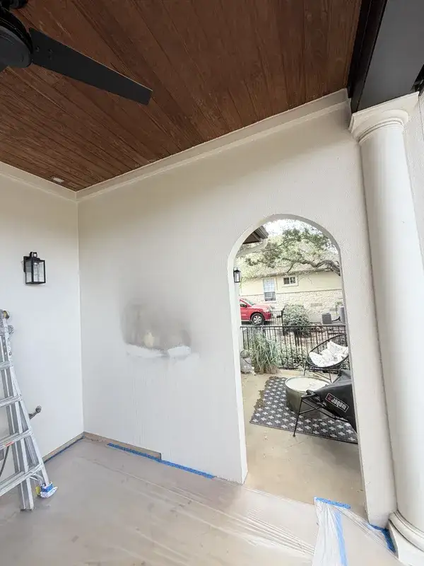 Covered patio before painting — prep and patching visible, Austin TX